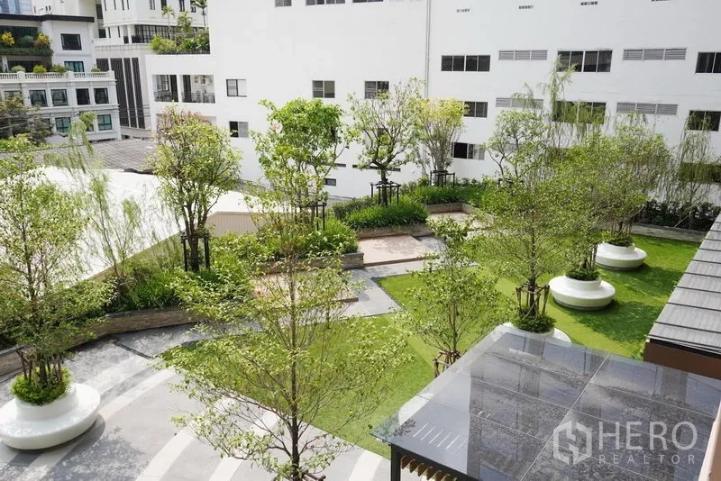 Condominium for rent in Pathum Wan, Bangkok - Landscaped condominium garden courtyard with trees, lawns, and seating areas.