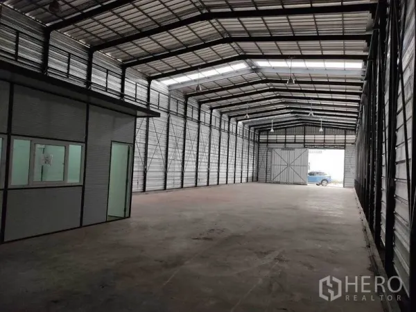 Warehouse for rent in Bang Phli, Samut Prakan - Spacious high‑ceiling steel warehouse with skylight roof, concrete floor, internal office and large sliding door.