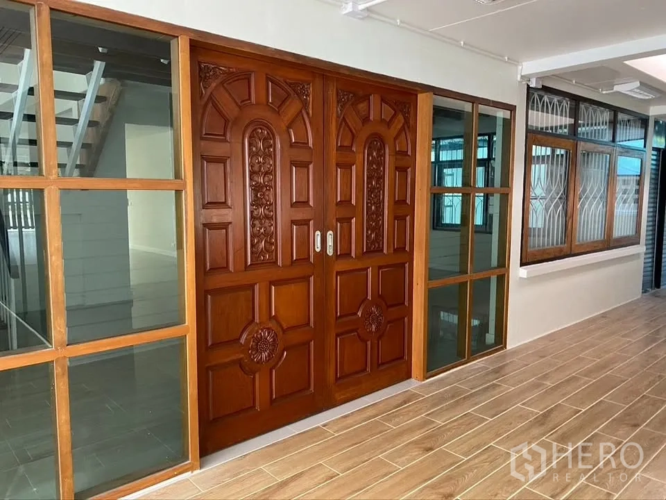 独栋房屋 for rent in Suan Luang, Bangkok - 雕花木质双开入户门，旁侧为玻璃固定窗。