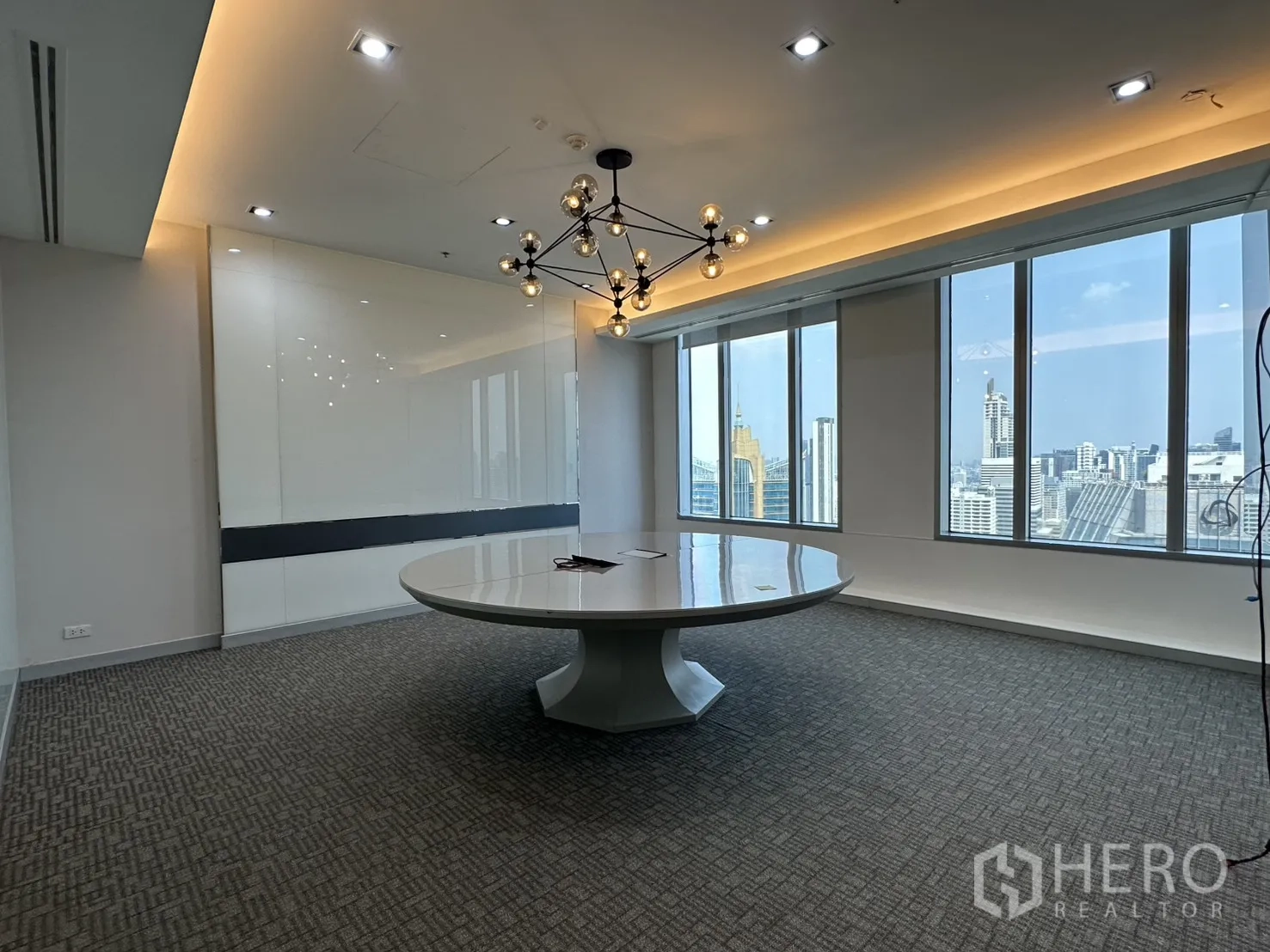 Office Space for rent in Khlong Toei, Bangkok - Meeting room with wide windows offering skyline views and recessed lighting.