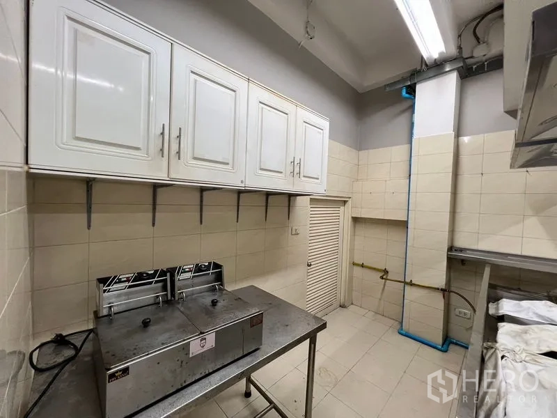 店屋 出租在Suan Luang, Bangkok - 商用厨房，白色吊柜与不锈钢设备，墙地瓷砖饰面。