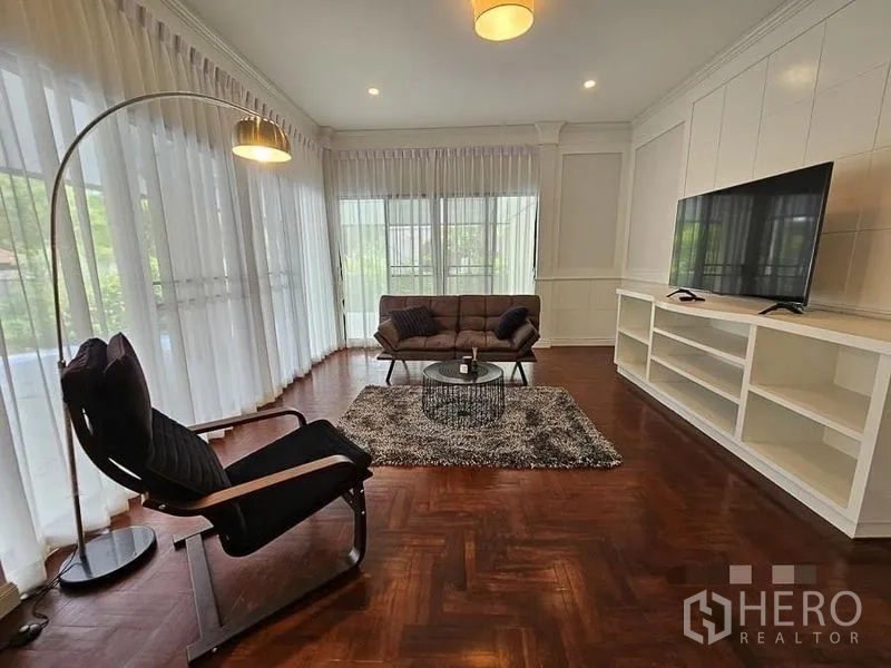 Detached House for rent - Family lounge with TV, built-in shelving, parquet flooring, and curtain-lined windows.