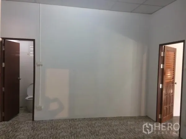Warehouse for rent in Pathum Thani - Office room with two doorways leading to restrooms, suitable for administrative use within the warehouse.