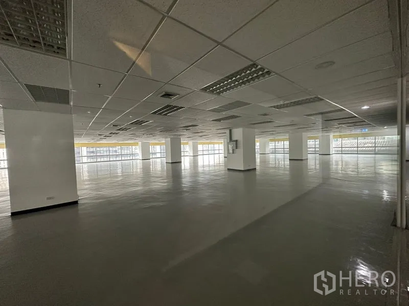 Office Space for rent - Large empty office space with grid ceiling lighting and wraparound glazing for abundant daylight.