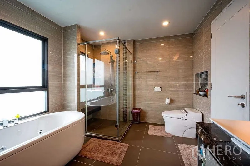 Detached House for sale in Prawet, Bangkok - Contemporary bathroom featuring a freestanding tub, glass shower and smart toilet.