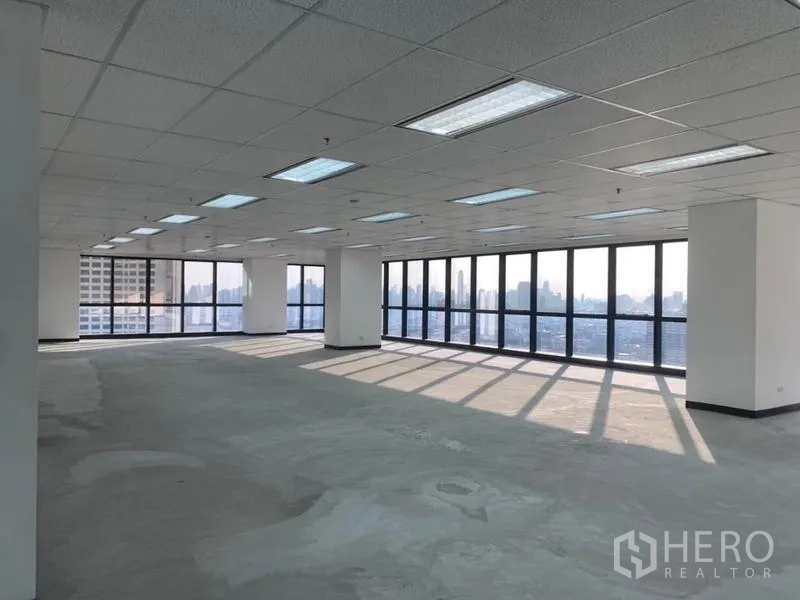 Office Space for rent in Din Daeng, Bangkok - Large unfurnished office showing panoramic city‑facing glazing and suspended grid ceiling.