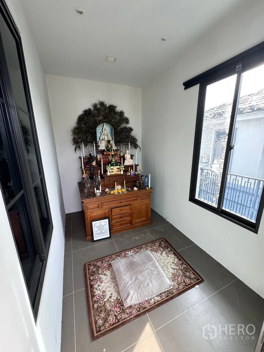 Detached House for sale in Mueang Pathum Thani, Pathum Thani - Prayer room with wooden altar and rug by windows.