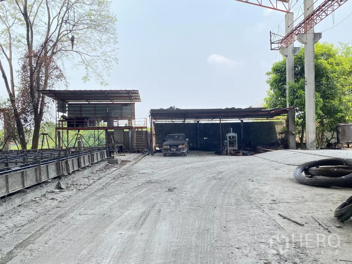 Factory for sale in Chon Buri - Service zone with small workshop sheds, elevated control room and wide driveway for trucks.