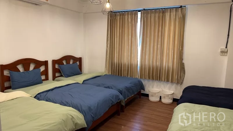 Home Office for rent or sale in Phra Khanong, Bangkok - Bedroom with three single beds, neutral curtains and pendant lights.
