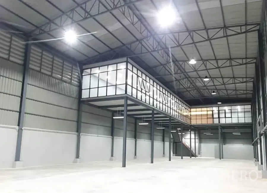 Warehouse for rent in Bang Khen, Bangkok - Open warehouse interior with high steel roof, mezzanine glass offices and bright LED lights.