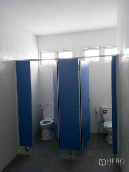 货栈 出租在Suan Luang, Bangkok - 干净的卫生间，蓝色隔断间与白色坐便器。