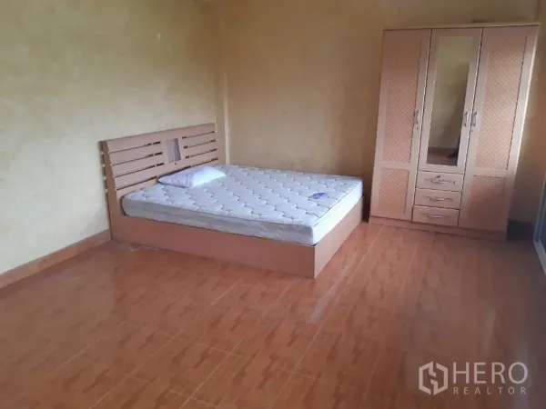 Townhouse for rent in Khlong Toei, Bangkok - Bright bedroom with tiled flooring, a bed and matching wardrobe.