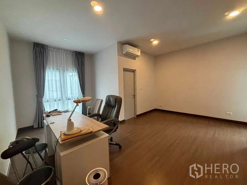 Detached House for rent in Mueang Nonthaburi, Nonthaburi - Large multipurpose room with desk, office chairs, air-conditioning and wood flooring.