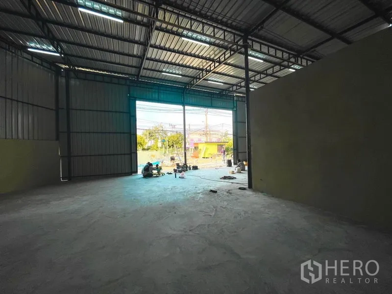 货栈 出租在Sai Mai, Bangkok - 仓库内部高挑空间，混凝土地面，正面大开口通向院子。