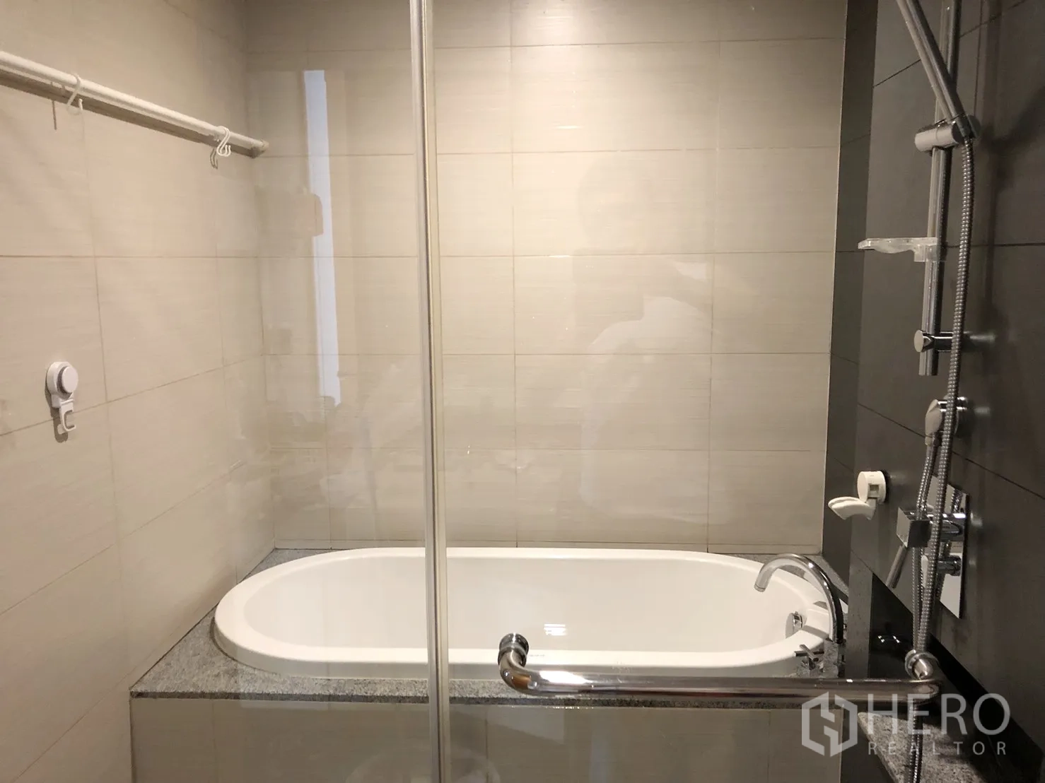 Condominium for rent or sale in Khlong Toei, Bangkok - Bathroom featuring built-in bathtub, glass partition and modern shower fixtures.