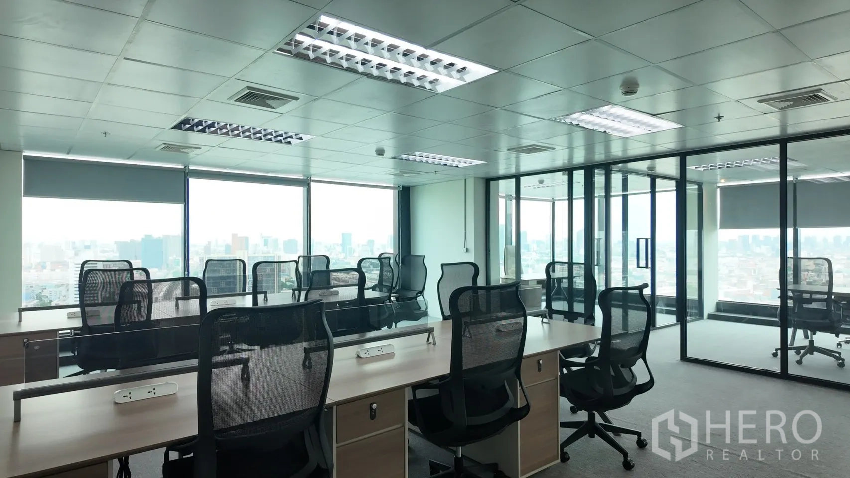办公室 for rent in Din Daeng, Bangkok - 开放式办公区设多组工位与网面椅，玻璃隔断办公室面向城市景观。