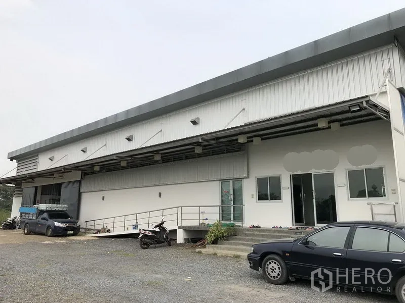 Factory for rent or sale in Wang Noi, Phra Nakhon Si Ayutthaya - Covered loading bay with ramp access, sliding doors and on-site parking in front of the factory.
