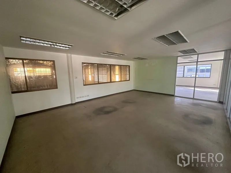 Warehouse for rent in Saphan Sung, Bangkok - Large office room beside warehouse with sliding glass door and windows.