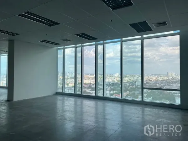 Office Space for rent - Corner workspace with full-height windows overlooking Bangkok cityscape.