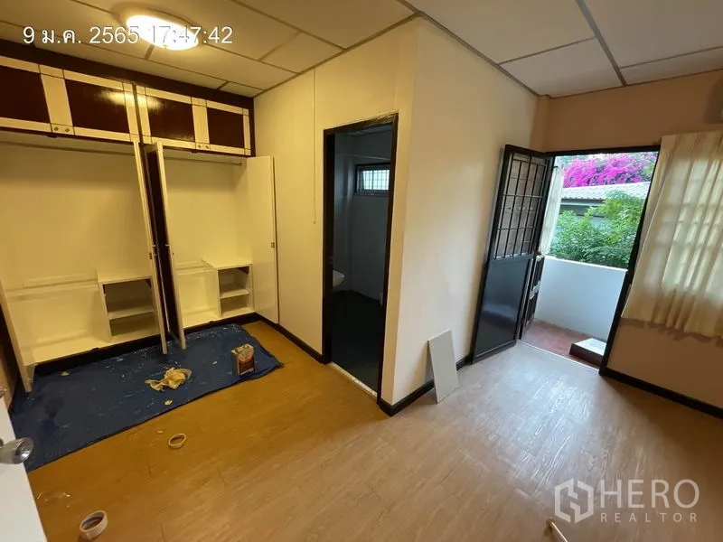 独立式住宅 出租在Khlong Toei, Bangkok - 卧室配内置衣柜，并有门通向开满花的小阳台。