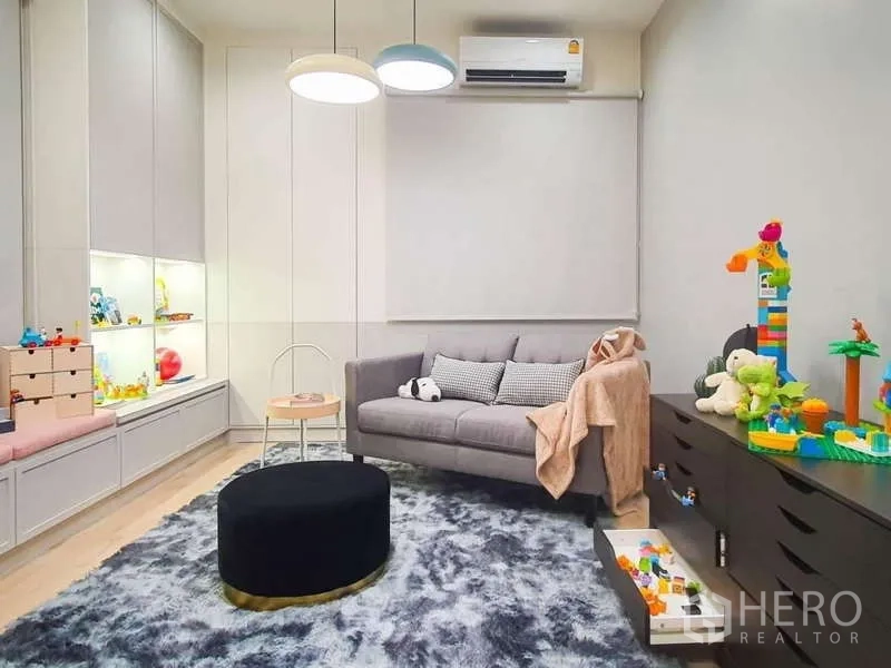 Detached House for rent in Sathon, Bangkok - Children’s playroom with sofa, plush rug, built-in storage, and toys.