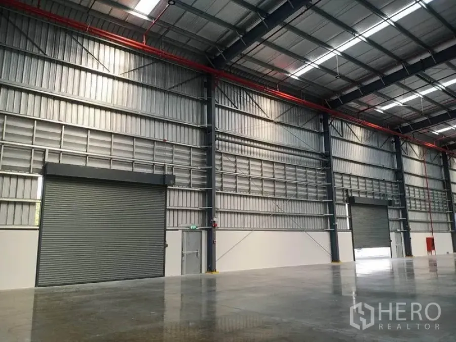 工厂 出租在Mueang Rayong, Rayong - 高挑厂房内部，钢结构、采光天窗、消防喷淋与大型卷闸门。