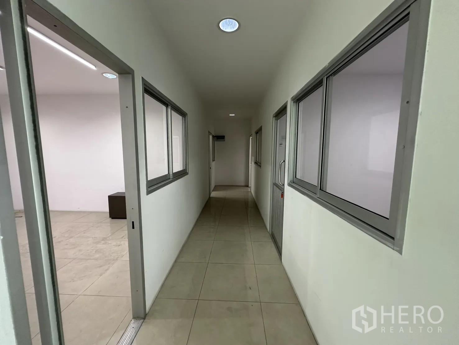 Factory for rent - Office corridor with multiple rooms and internal windows.