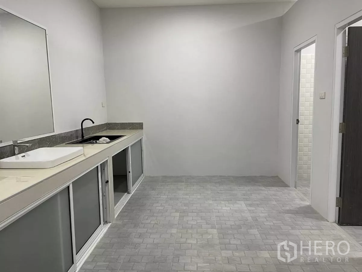 Factory for rent or sale in Bang Phli, Samut Prakan - Pantry area featuring long countertop, sink, large wall mirror, and under-counter storage.