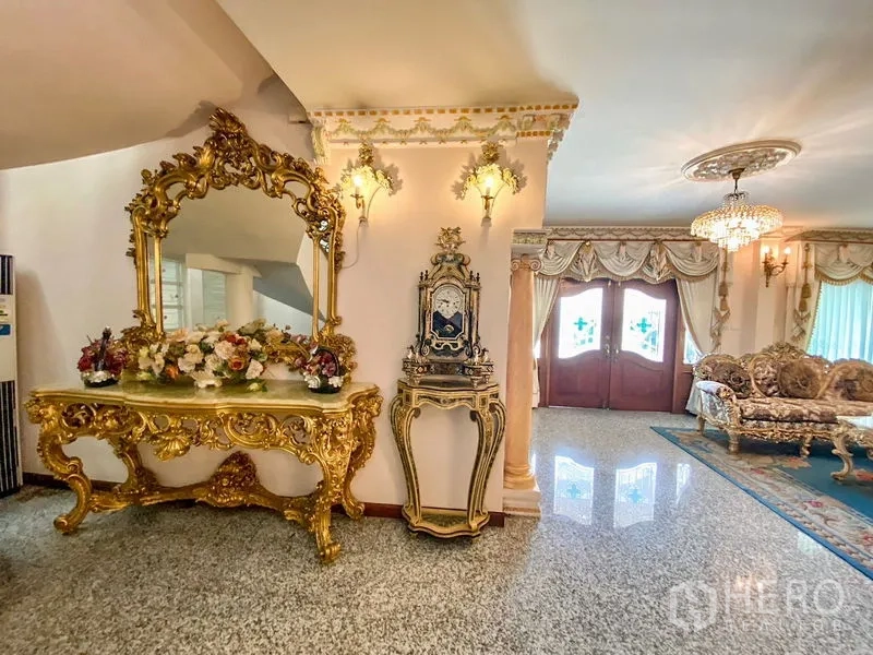 Detached House for rent or sale in Bang Khen, Bangkok - Grand foyer with gilded mirror, antique clock, chandelier, and double wooden doors.