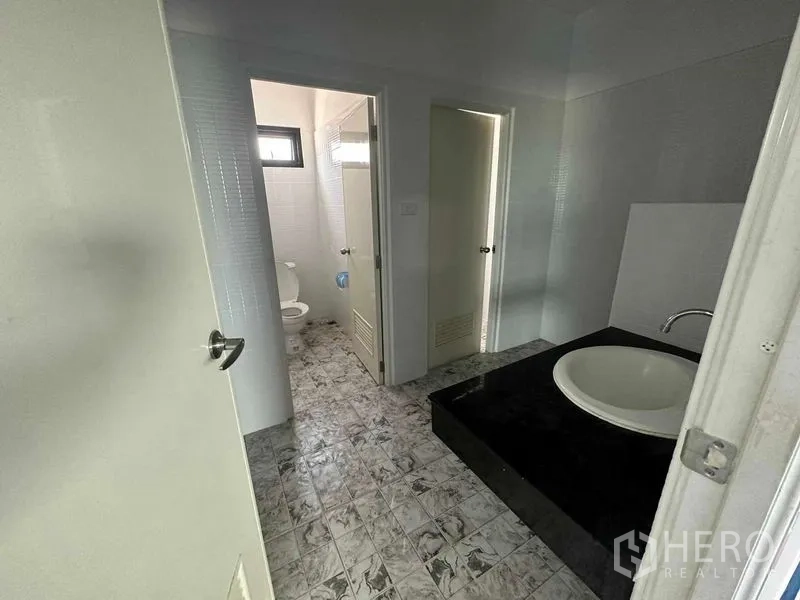 Warehouse for sale in Khlong Luang, Pathum Thani - Restroom area featuring separate toilet cubicles and a basin counter.