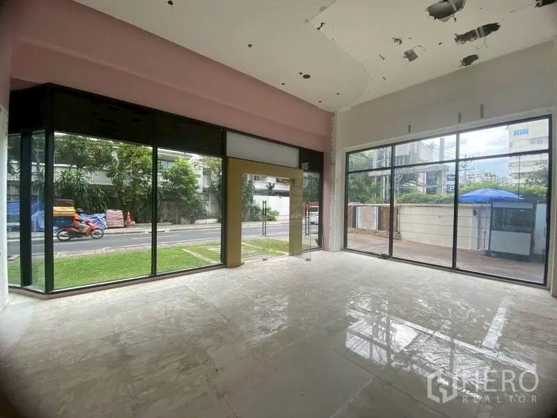 Retail Space for rent in Watthana, Bangkok - Bright shop interior with two glass walls and gold-framed door to street.