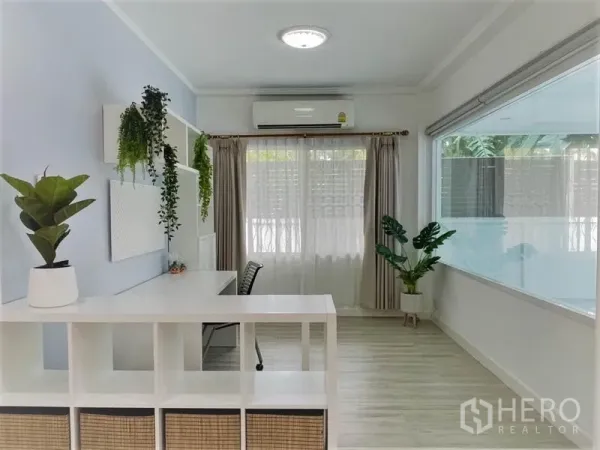 Detached House for rent in Suan Luang, Bangkok - Light-filled study area with desk, shelves, air conditioner and indoor plants by a big window.
