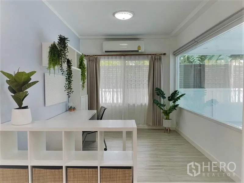 Detached House for rent in Suan Luang, Bangkok - Light-filled study area with desk, shelves, air conditioner and indoor plants by a big window.