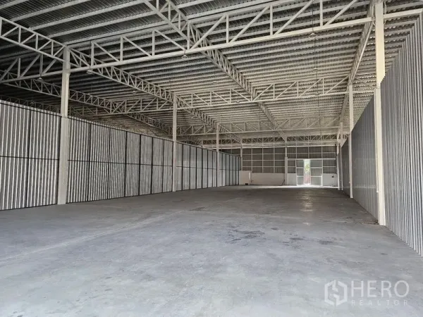 Warehouse for rent in Khlong Toei, Bangkok - Spacious empty warehouse interior with high steel truss roof and durable concrete flooring.