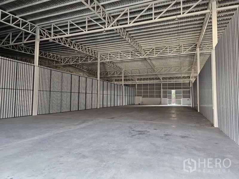 Warehouse for rent in Khlong Toei, Bangkok - Spacious empty warehouse interior with high steel truss roof and durable concrete flooring.