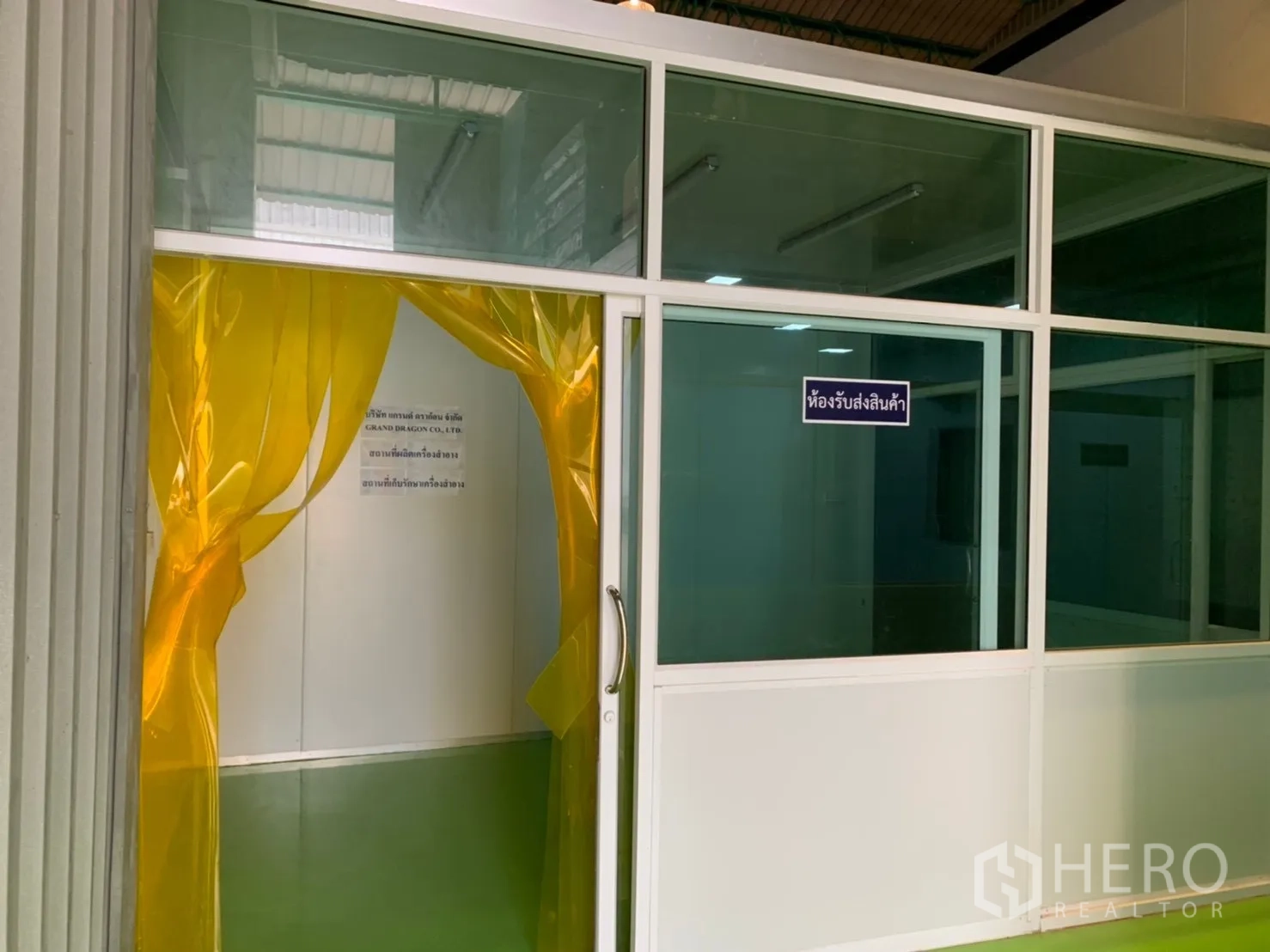 Factory for rent in Khlong Luang, Pathum Thani - Receiving room entrance with yellow strip curtains and a glass partition.