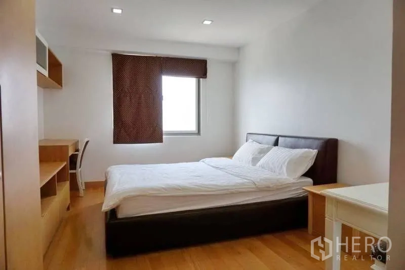 Condominium for rent in Watthana, Bangkok - Second bedroom with double bed, desk and wardrobe on wooden flooring.