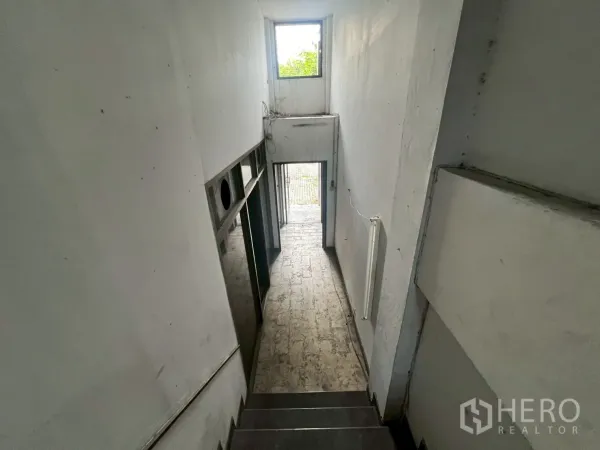 Shophouse for rent in Phra Khanong, Bangkok - Interior stairwell and corridor with natural light from a rear window.