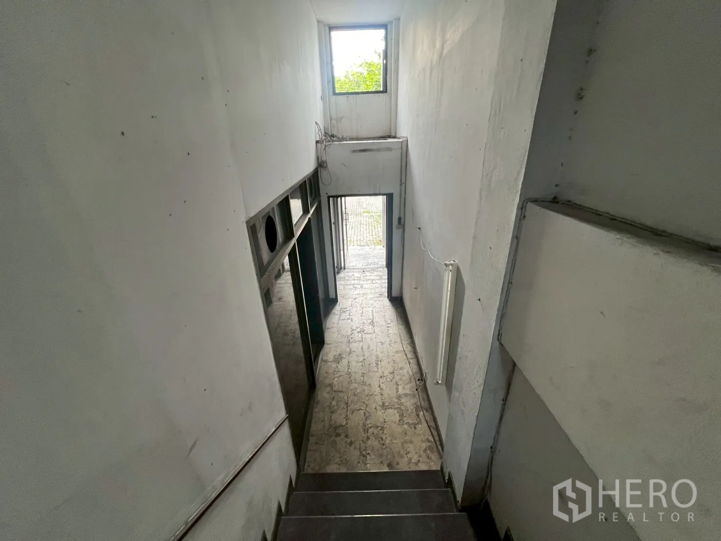 Shophouse for rent in Phra Khanong, Bangkok - Interior stairwell and corridor with natural light from a rear window.