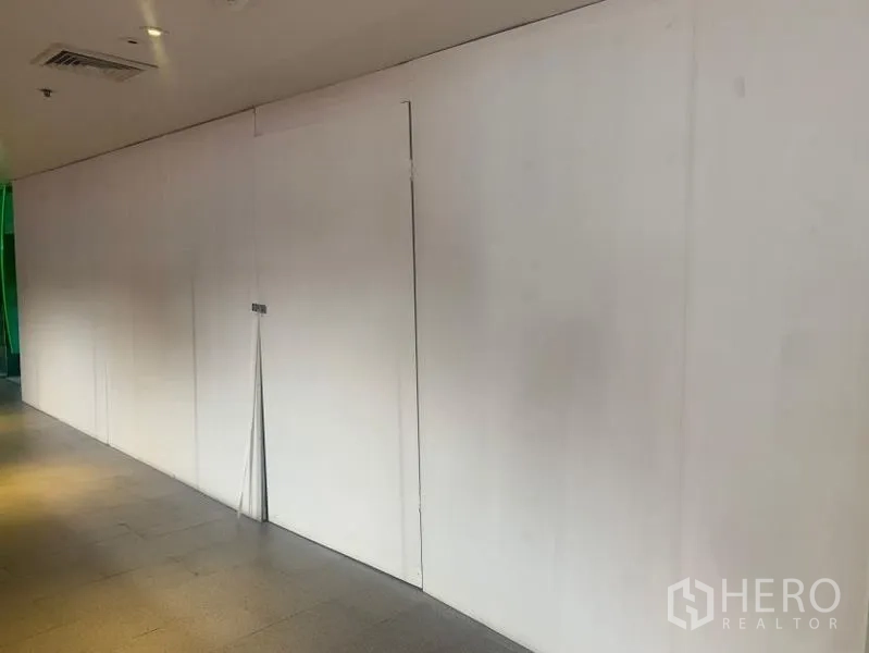 Retail Space for rent - Close-up of a temporary white wall and single door marking a retail unit under fit-out.