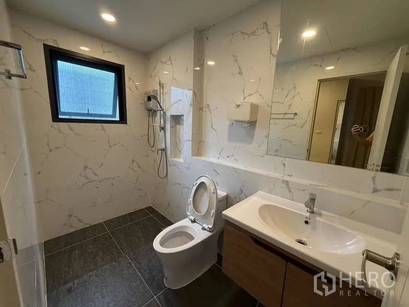 Detached House for sale in Bang Phli, Samut Prakan - Modern ensuite bathroom with shower, vanity and marble-look wall tiles.
