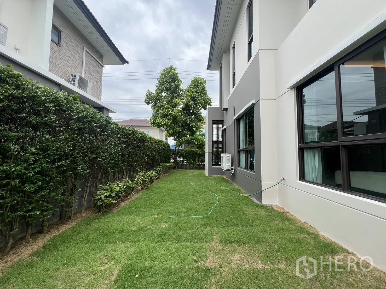 Detached House for rent or sale in Prawet, Bangkok - Rear garden with tall hedge providing privacy.