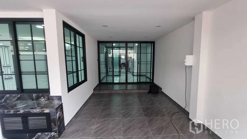 Townhouse for rent in Khlong Toei, Bangkok - Front foyer with floor-to-ceiling sliding glass doors and tiled flooring.