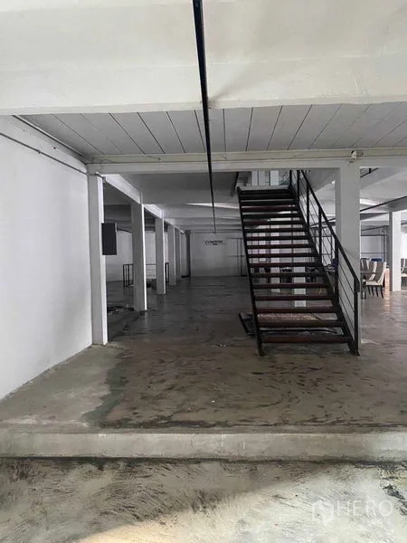 Retail Space for rent in Bang Na, Bangkok - Industrial staircase leading to the upper floor in a large concrete hall.