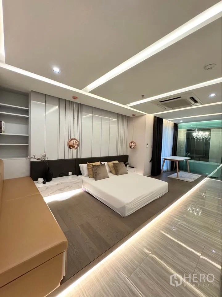 Condominium for rent or sale in Khlong Toei, Bangkok - Primary bedroom with platform bed, LED floor lighting and glass-walled bathroom.