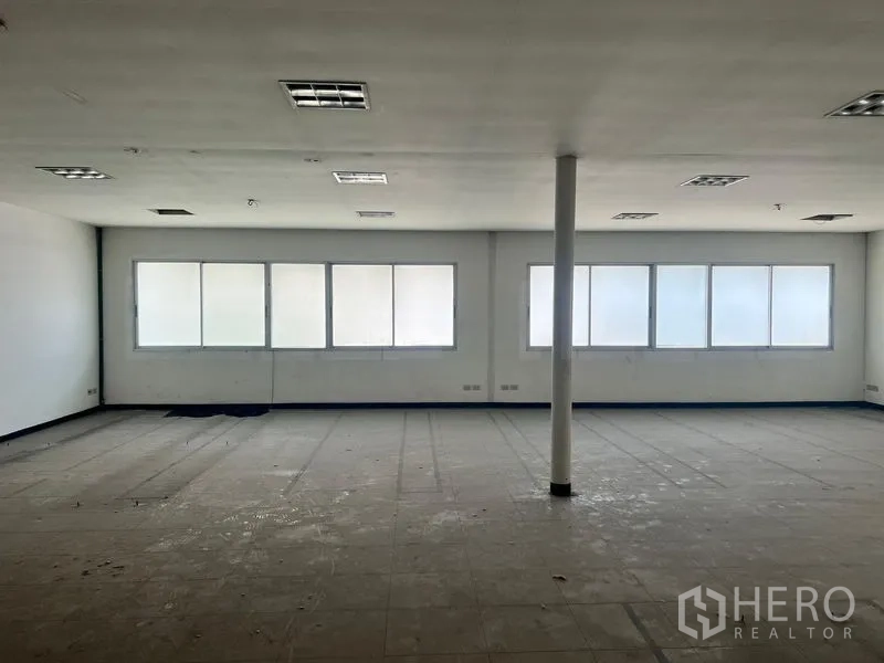 Warehouse for rent in Suan Luang, Bangkok - Open-plan upper floor workspace with frosted windows providing natural light across the room.