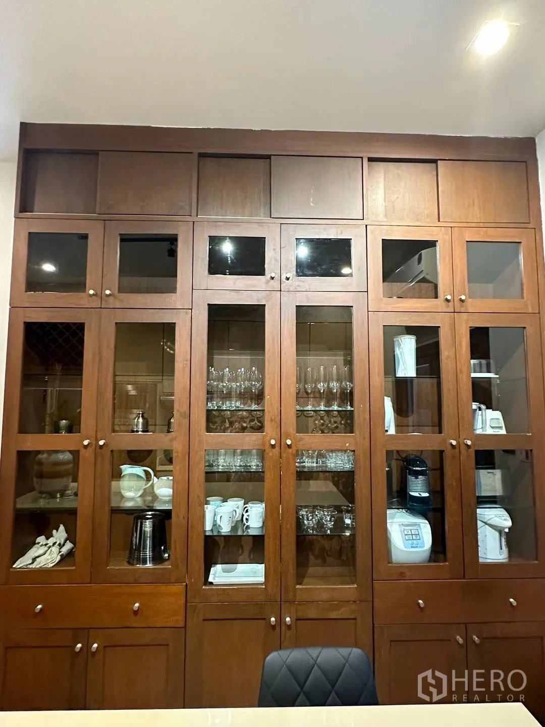 Detached House for rent in Watthana, Bangkok - Tall wooden built-in cabinet with glass doors displaying glassware and appliances.