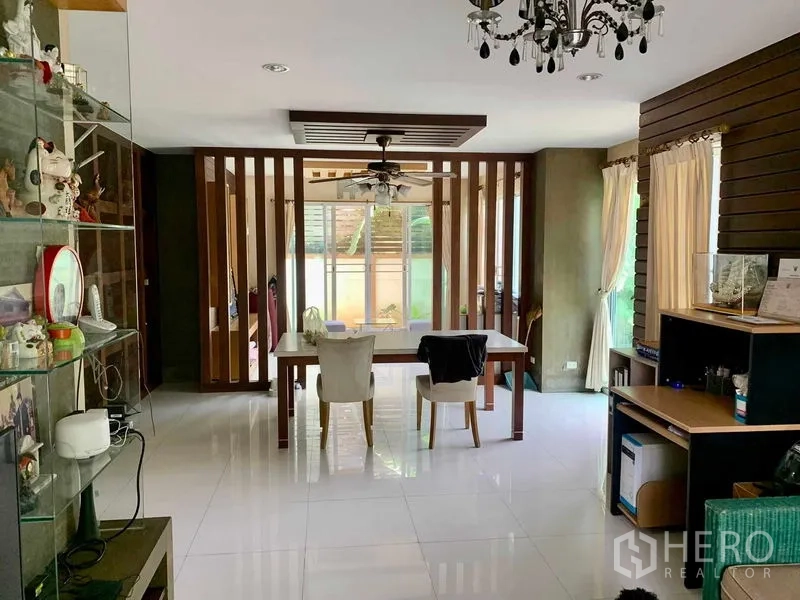 Detached House for rent in Prawet, Bangkok - Open-plan dining area with wooden slat divider and chandelier.