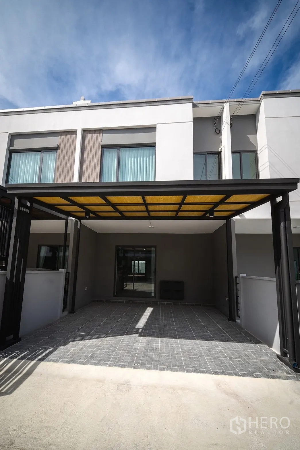 Townhouse for rent in Bang Phli, Samut Prakan - Modern two-storey townhouse facade with wide carport and canopy.