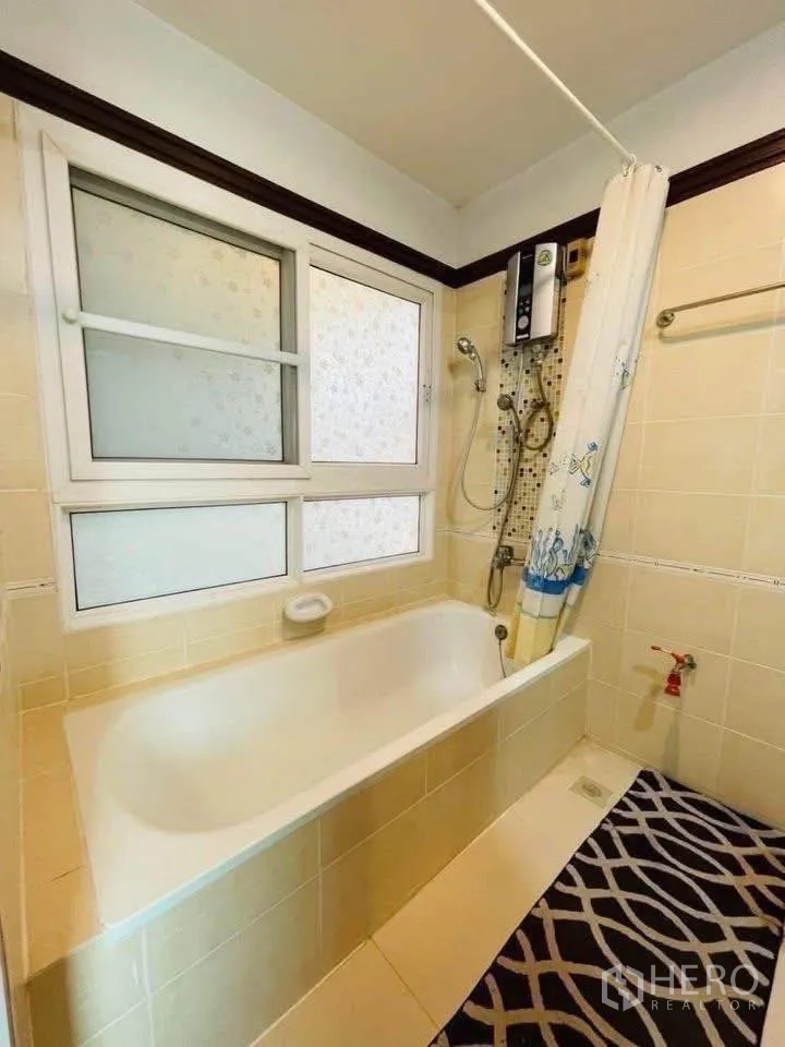 Detached House for rent or sale in Lam Luk Ka, Pathum Thani - Bathroom with bathtub, shower heater and frosted windows.